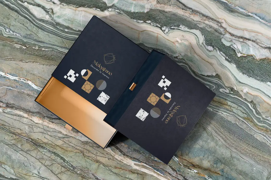 Open navy packaging with the faceted mark and a gold inlay on green marble